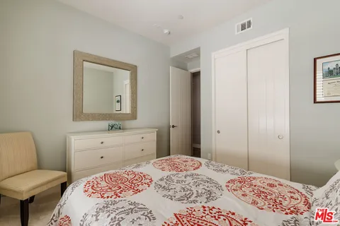 a bedroom with a bed and a dresser in it