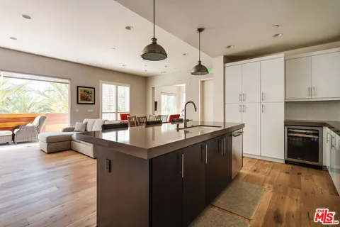 a kitchen with kitchen island a sink dining table and chairs