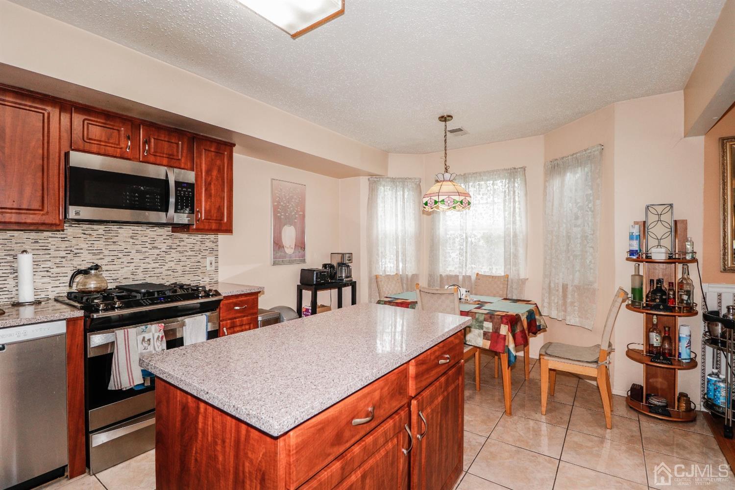 348 Lunar Road Piscataway, NJ 08854 - Photo 11 of 33 a kitchen with stainless steel appliances a stove a sink a microwave and dining table