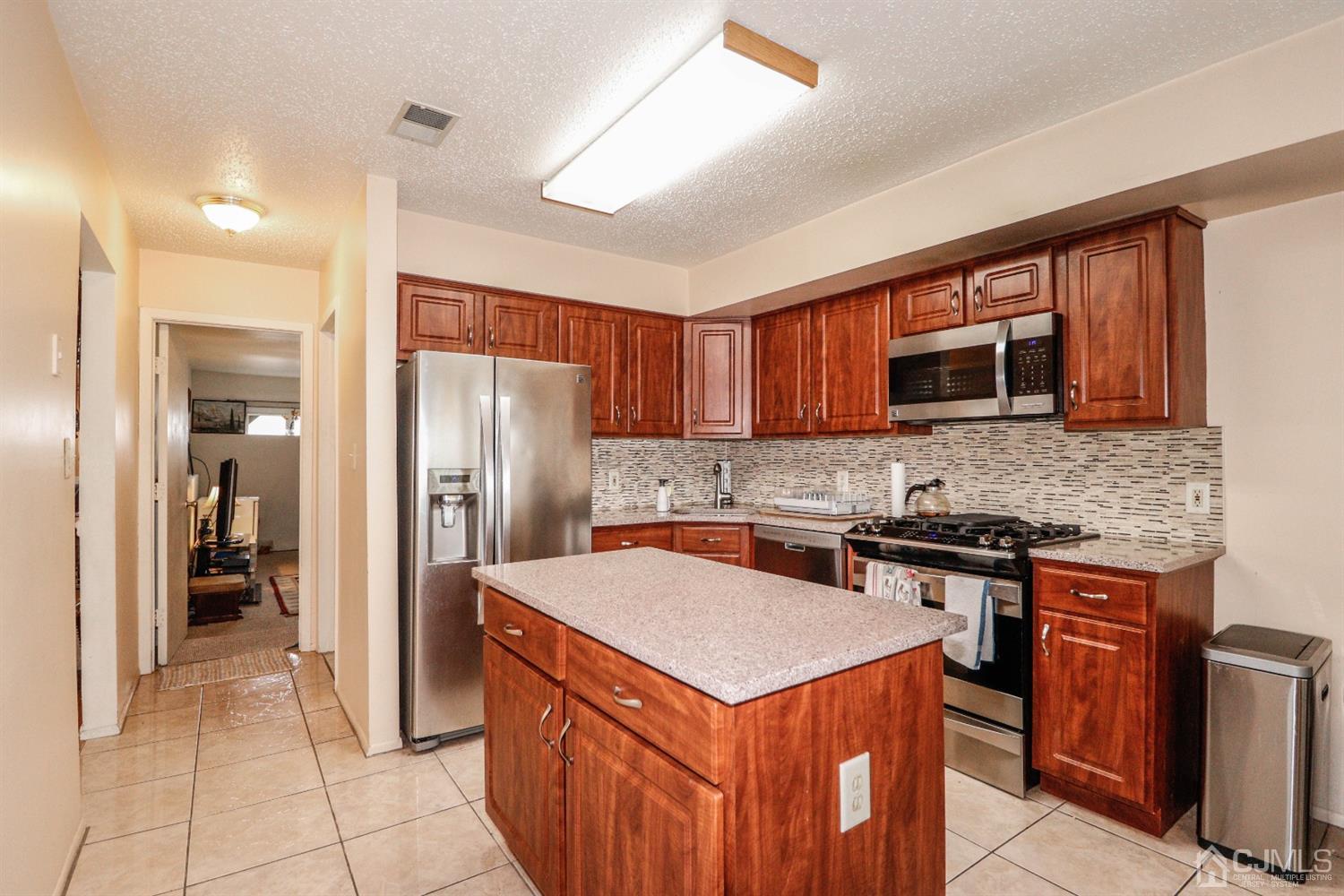 348 Lunar Road Piscataway, NJ 08854 - Photo 10 of 33 a kitchen with stainless steel appliances a sink stove and refrigerator