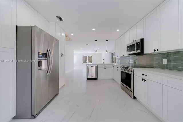 a kitchen with stainless steel appliances granite countertop a refrigerator and a stove