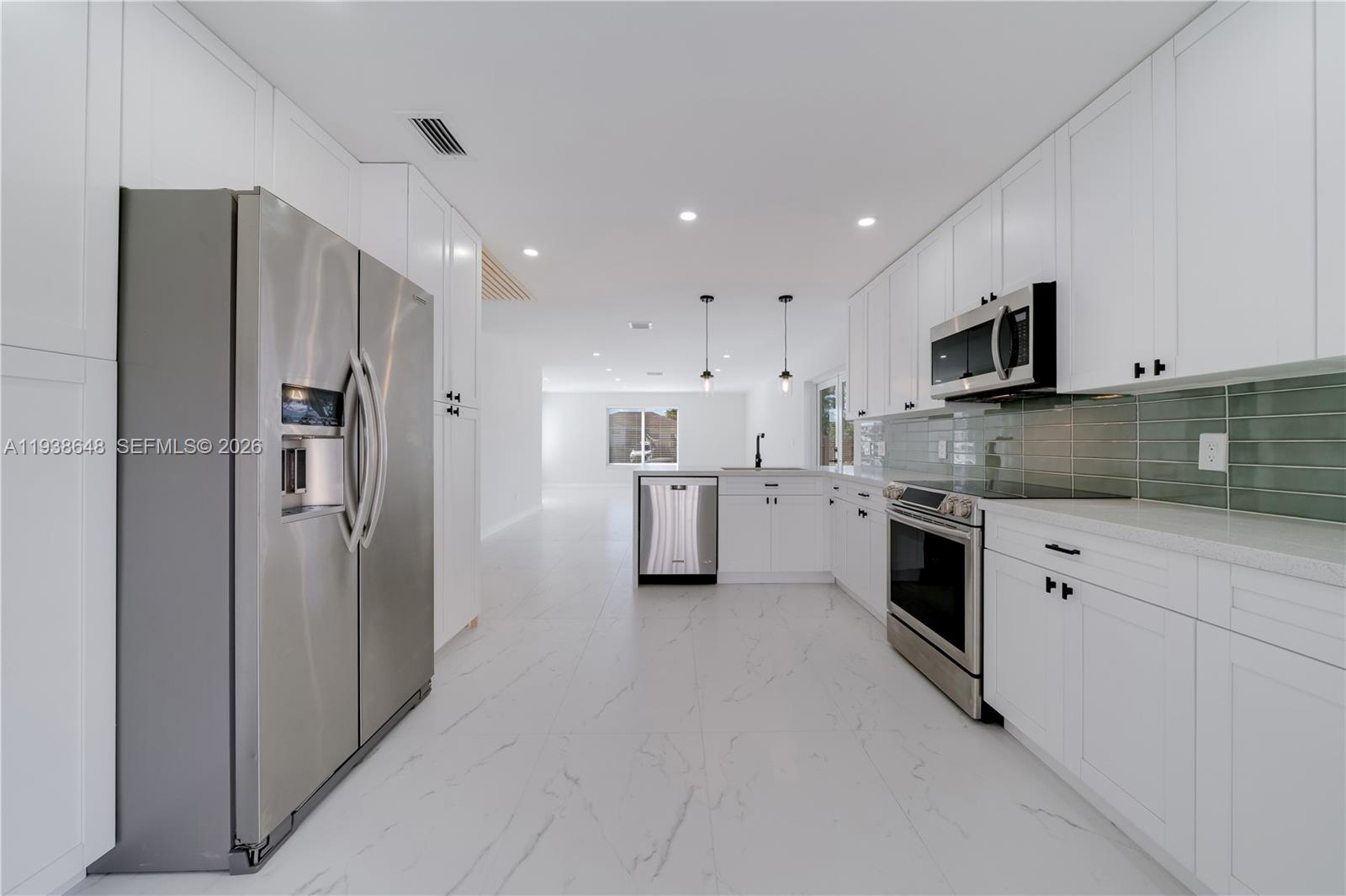 9826 Southwest 222nd Terrace, Unit 9826 Cutler Bay, FL 33190 - Photo 11 of 36 a kitchen with stainless steel appliances granite countertop a refrigerator and a stove