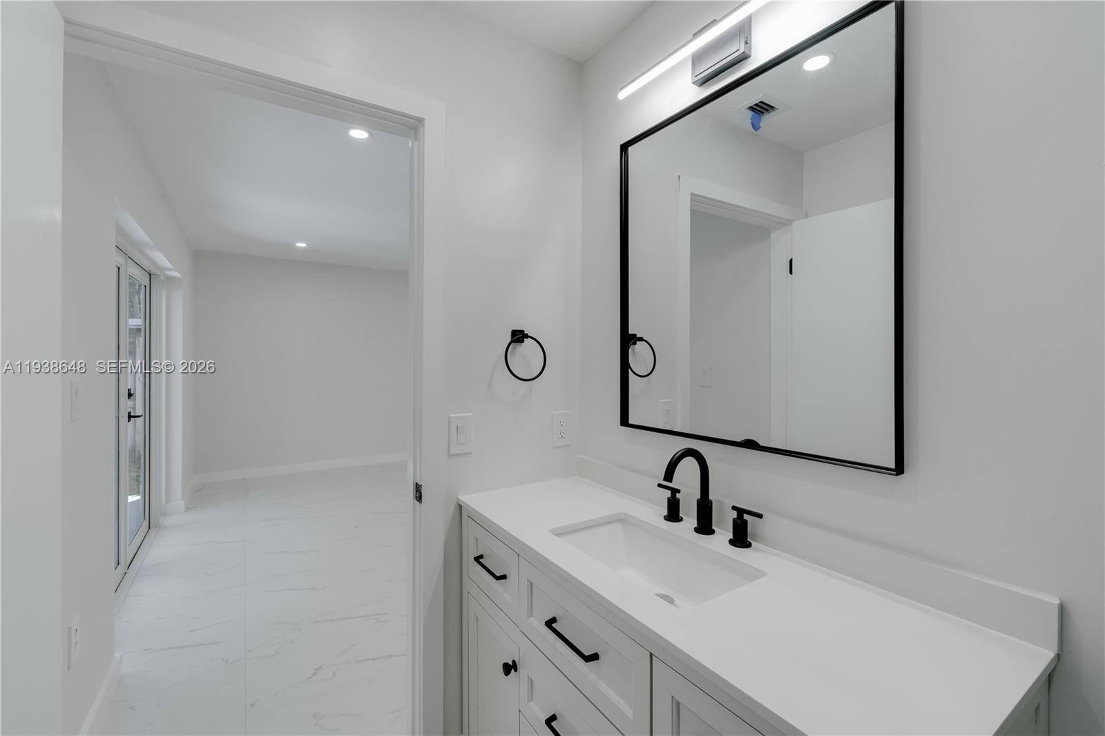9826 Southwest 222nd Terrace, Unit 9826 Cutler Bay, FL 33190 - Photo 16 of 36 a bathroom with a sink and a mirror