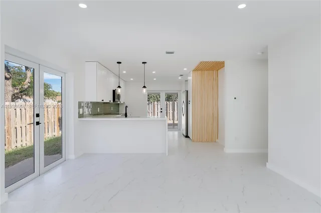 a view of a kitchen with refrigerator and windows