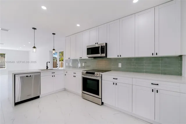 a kitchen with stainless steel appliances granite countertop a stove a sink and a microwave