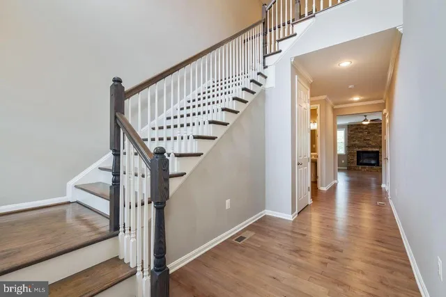 a view of a hallway with wooden floor and staircase