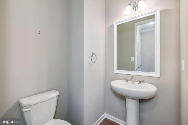 a bathroom with a sink toilet and mirror