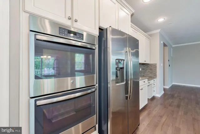 a kitchen with stainless steel appliances a refrigerator and a stove top oven
