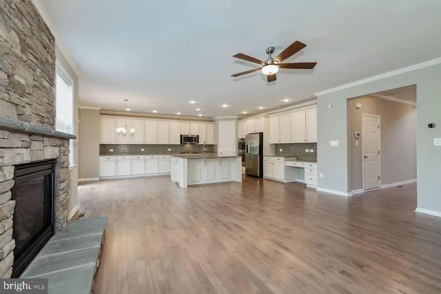 a view of an empty room and kitchen with kitchen appliances