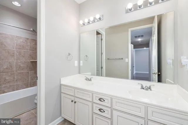 a front view of a house with a yard and potted plants