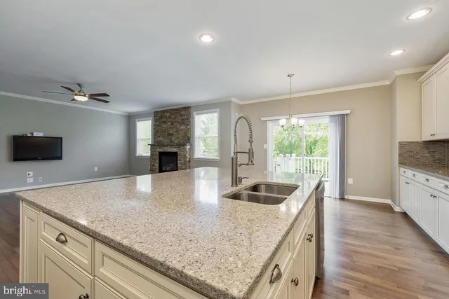 a kitchen with granite countertop a sink a counter top space and cabinets
