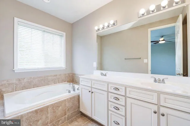 a bathroom with a tub a sink and mirror