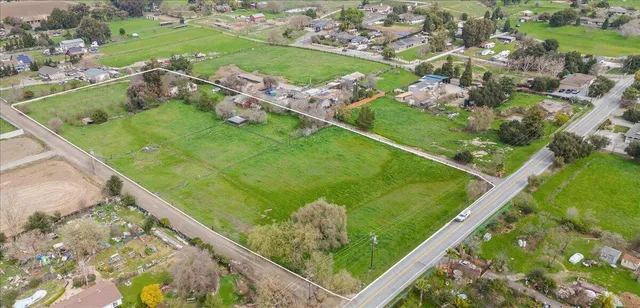 an aerial view of green landscape with trees houses and mountain view