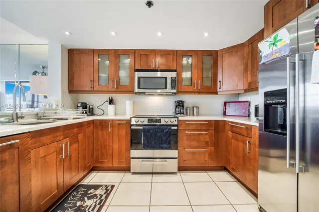 a kitchen with stainless steel appliances granite countertop a refrigerator and a stove top oven