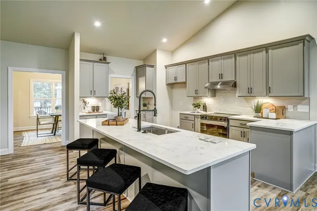 a kitchen with stainless steel appliances a dining table chairs and wooden cabinets