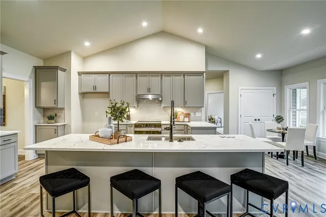 a kitchen with a sink a stove a refrigerator and chairs