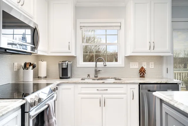 a kitchen with granite countertop a sink a stove and cabinets