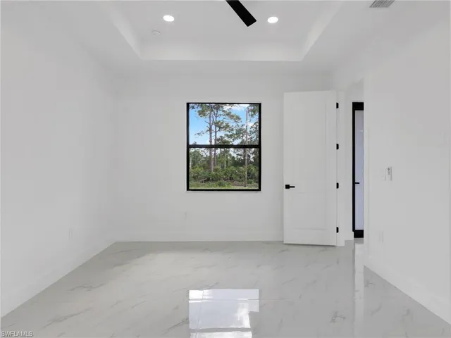 an empty room with a kitchen space and a window