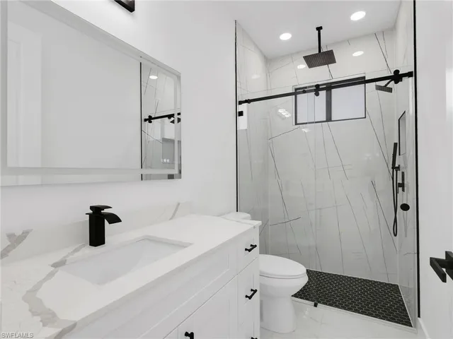 a bathroom with a sink a toilet and shower