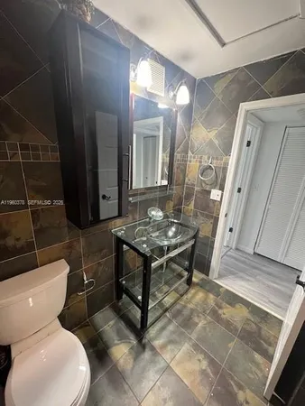 a bathroom with a toilet a sink and a mirror