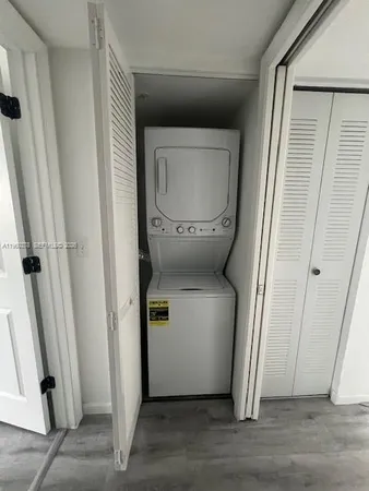 a utility room with wooden floor washer and dryer