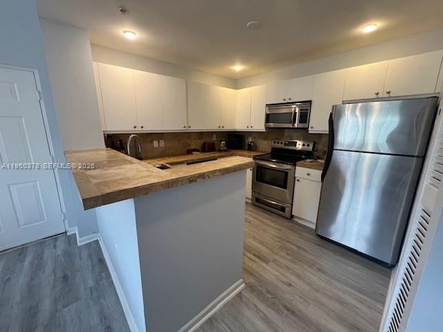 2103 Renaissance Boulevard, Unit 307 Miramar, FL 33025 - Photo 3 of 32 a kitchen with stainless steel appliances a refrigerator a sink a stove a microwave a center island and wooden floor
