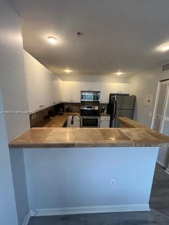 a view of kitchen countertops with furniture and a flat screen tv