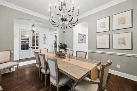 a view of a dining room with furniture a chandelier and wooden floor