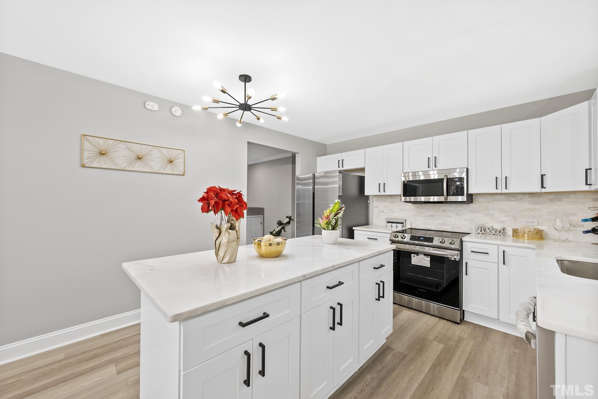 20 Lynn Road Raleigh, NC 27609 - Photo 12 of 29 a kitchen with stainless steel appliances granite countertop a sink dishwasher and white cabinets with wooden floor