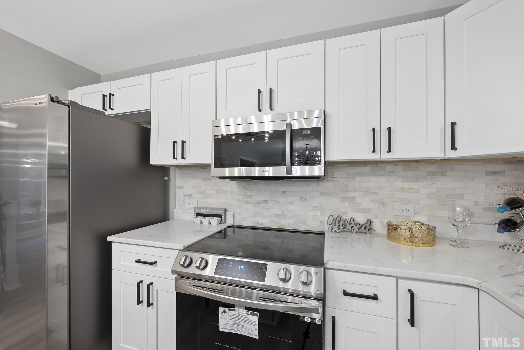 20 Lynn Road Raleigh, NC 27609 - Photo 14 of 29 a kitchen with stainless steel appliances white cabinets and a stove
