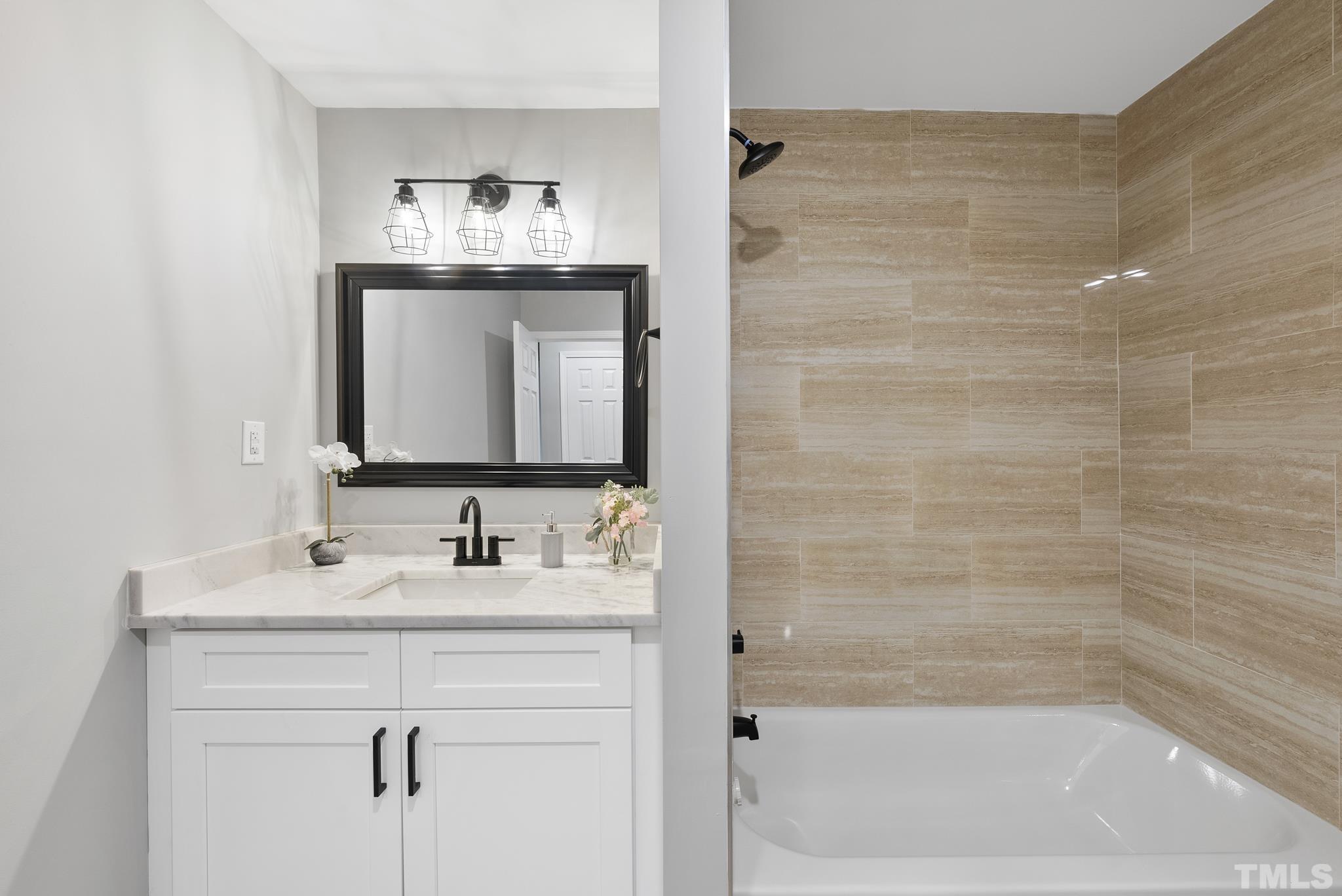 20 Lynn Road Raleigh, NC 27609 - Photo 20 of 29 a bathroom with a bathtub sink vanity and mirror