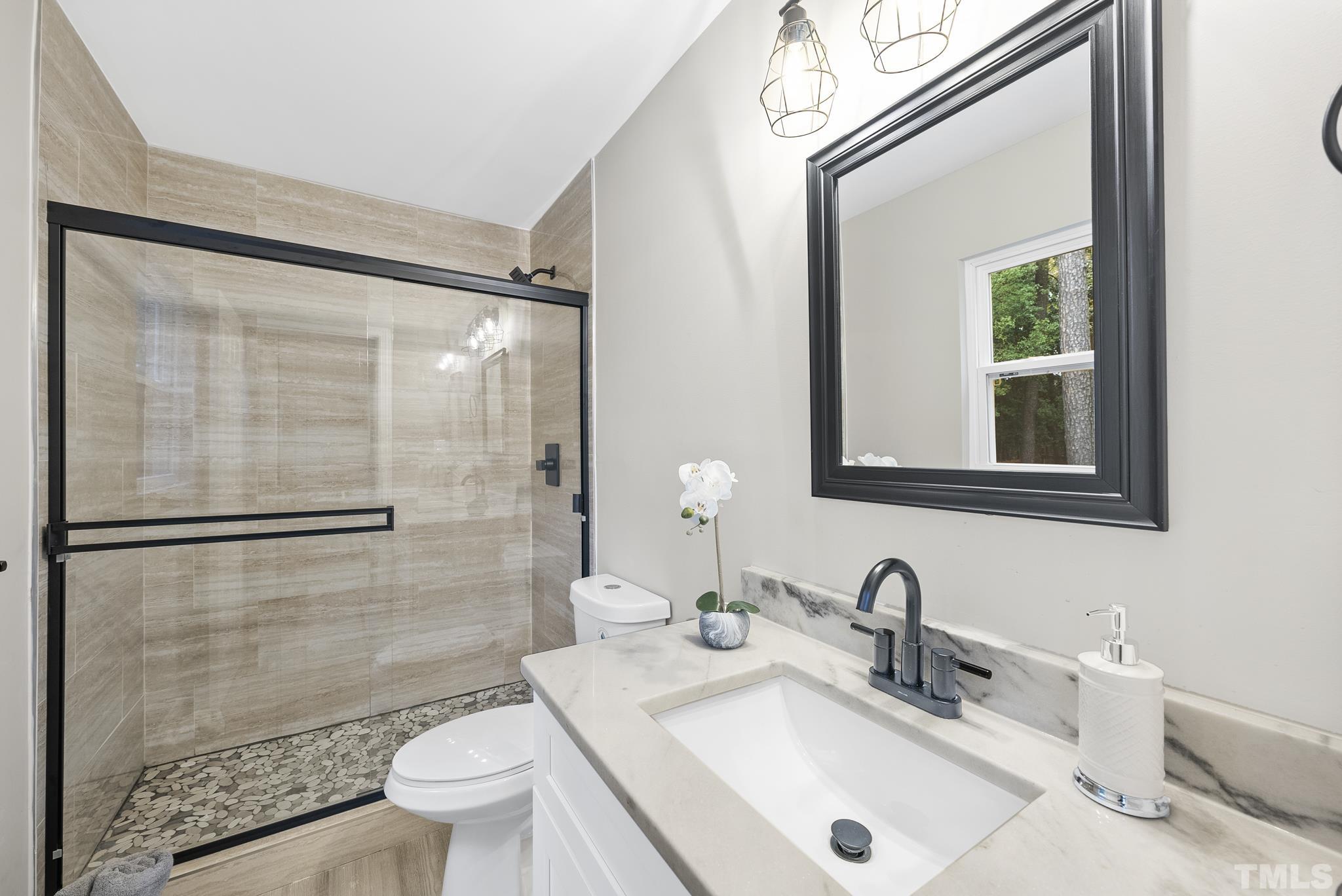 20 Lynn Road Raleigh, NC 27609 - Photo 25 of 29 a bathroom with a sink a toilet and a mirror