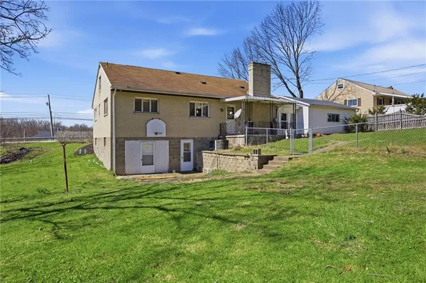 a front view of a house with a yard and fence