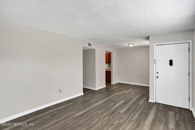 a view of an empty room with wooden floor