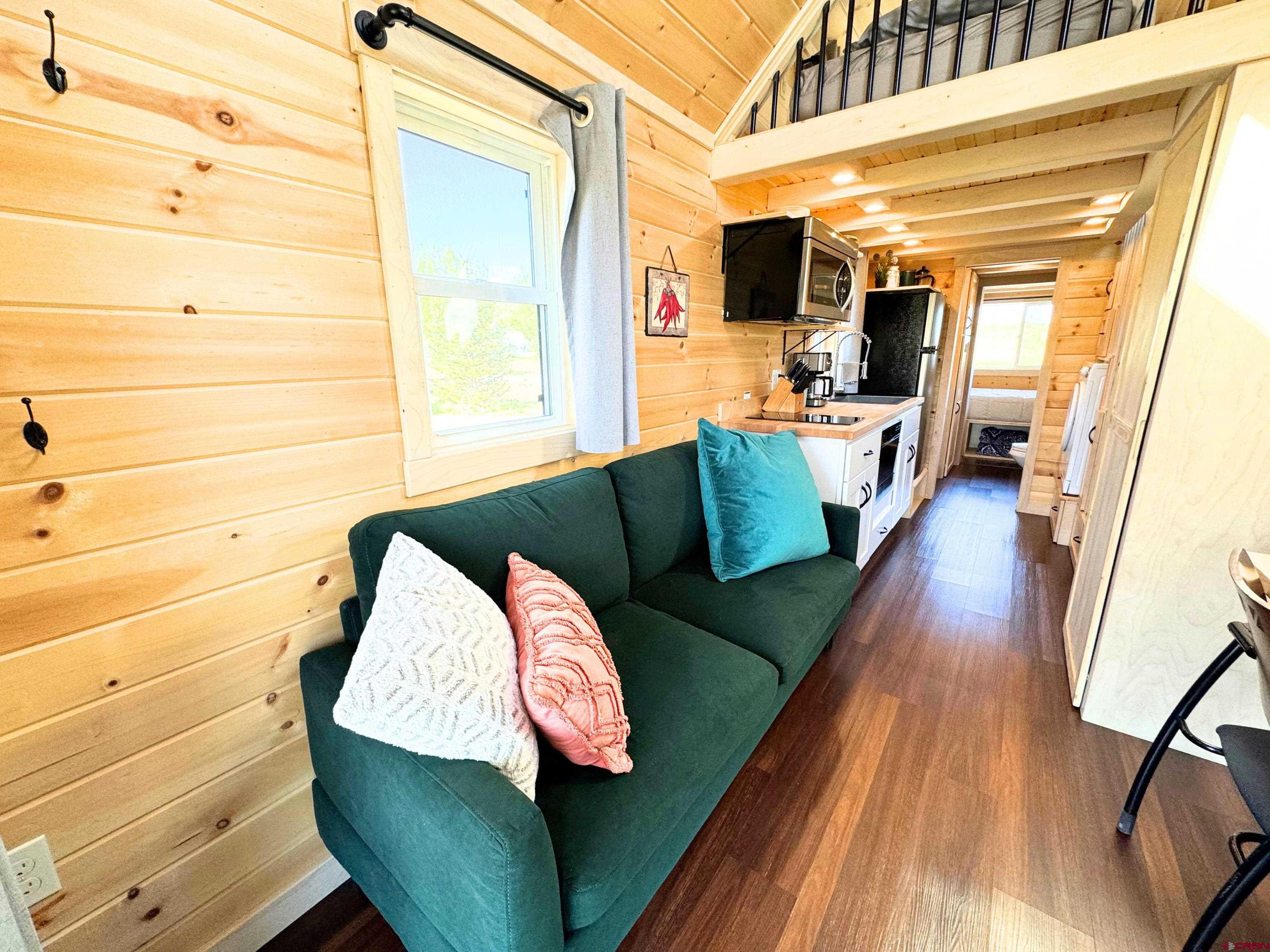 22130 6850 Road, Unit 213 Montrose, CO 81403 - Photo 2 of 26 a living room with furniture and a flat screen tv