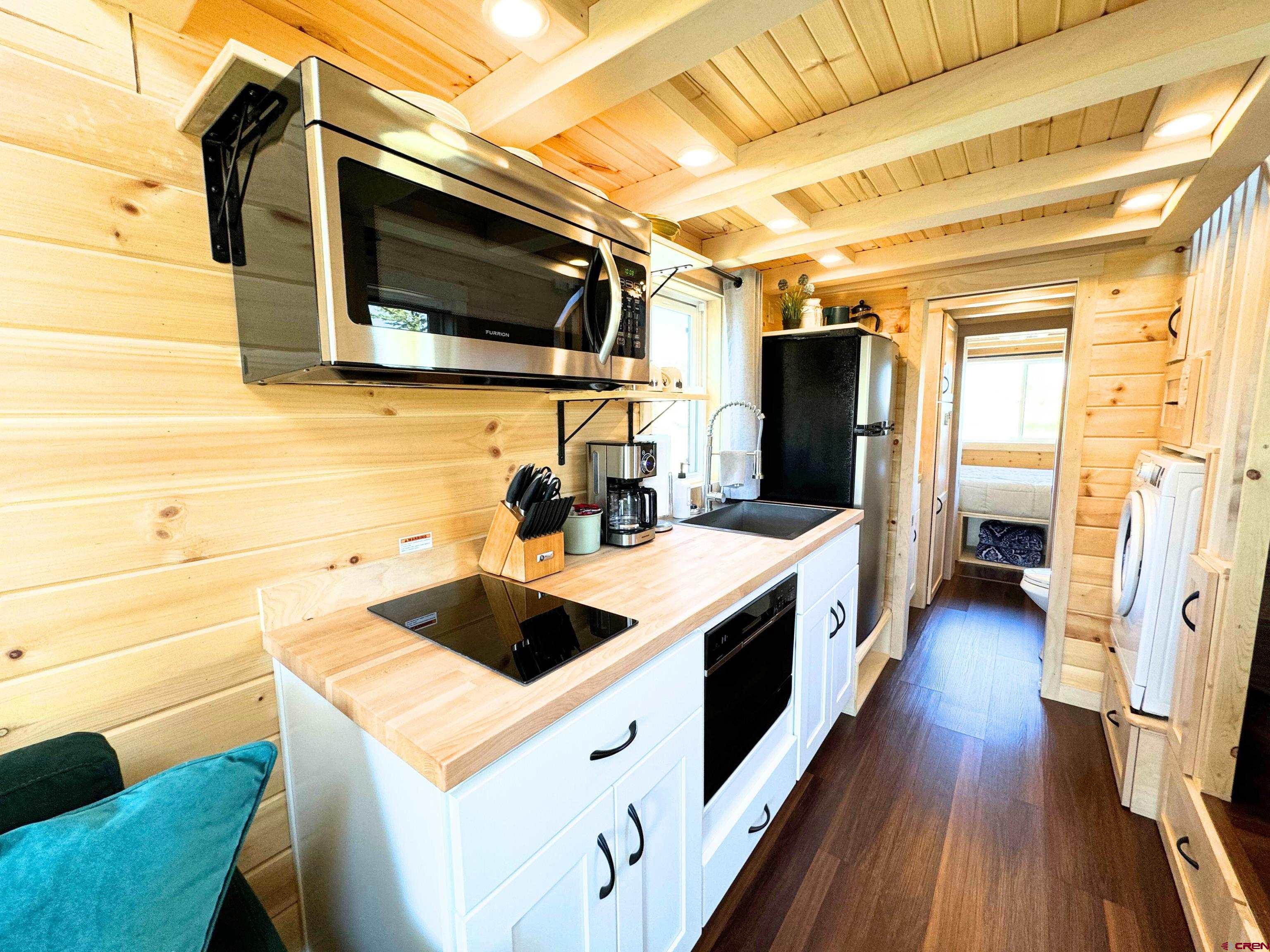 22130 6850 Road, Unit 213 Montrose, CO 81403 - Photo 5 of 26 a kitchen with stainless steel appliances a stove a microwave and a refrigerator