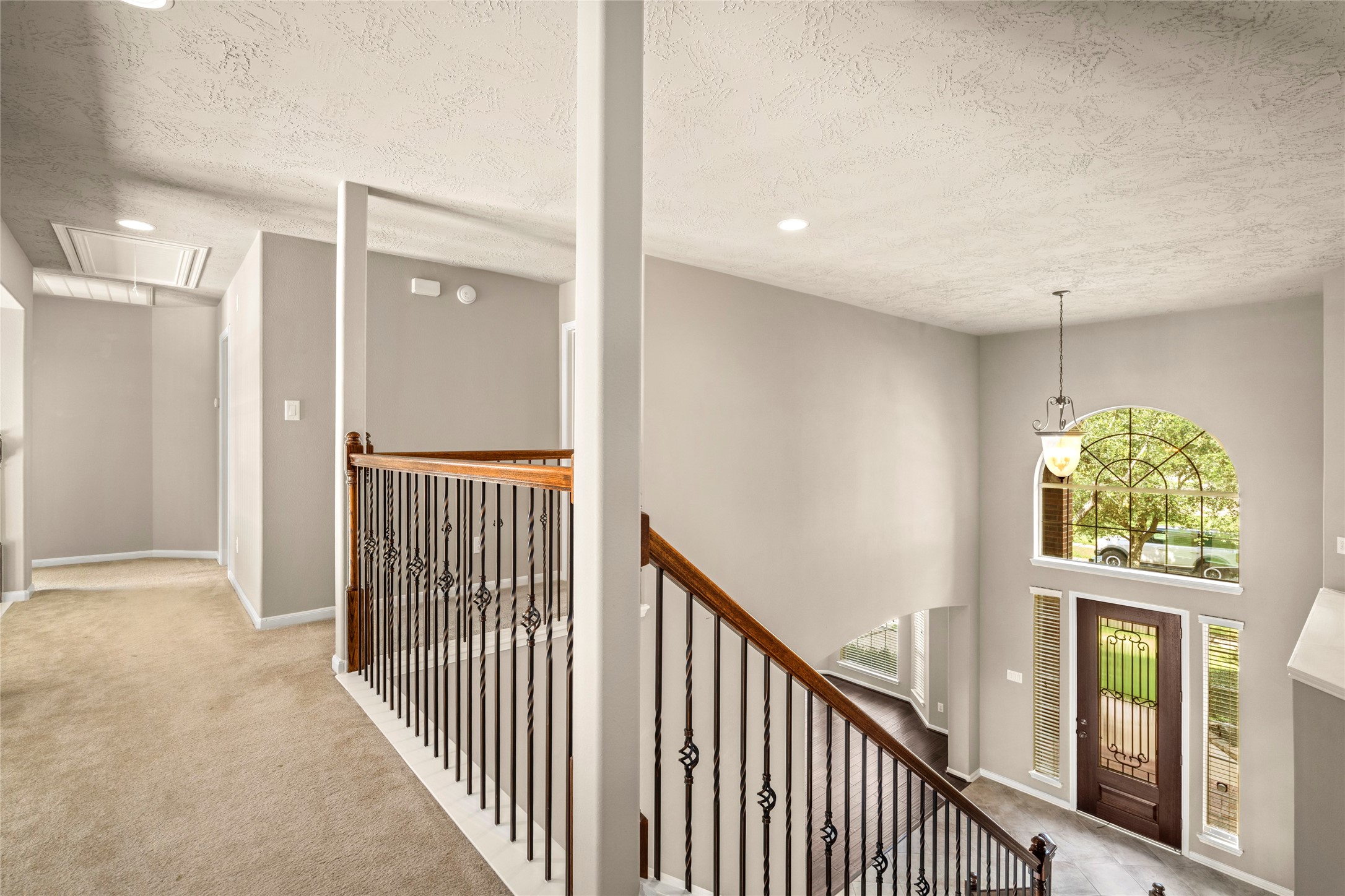 5307 Amber Sky Lane Rosharon, TX 77583 - Photo 30 of 50 A sleek metal-and-wood railing frames this bright open hallway overlooking the dramatic two-story living area below, an architectural highlight as you make your way to the upstairs retreats.