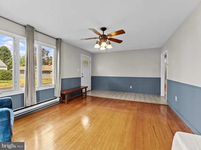 a view of an empty room with a window and a kitchen view