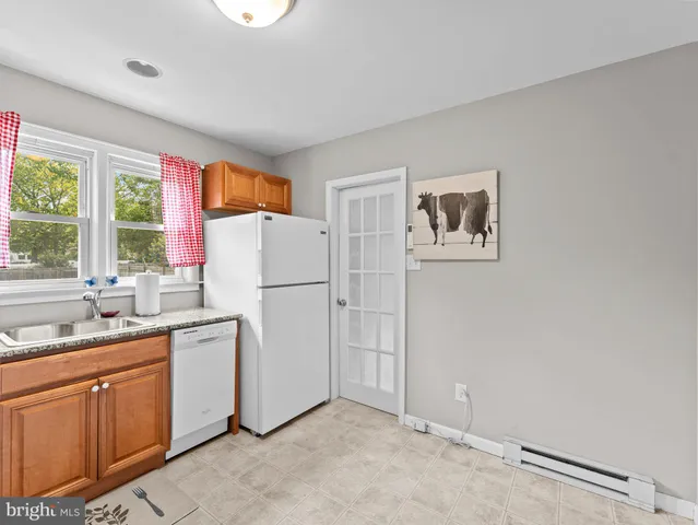 a kitchen with a refrigerator a sink and dishwasher with wooden floor