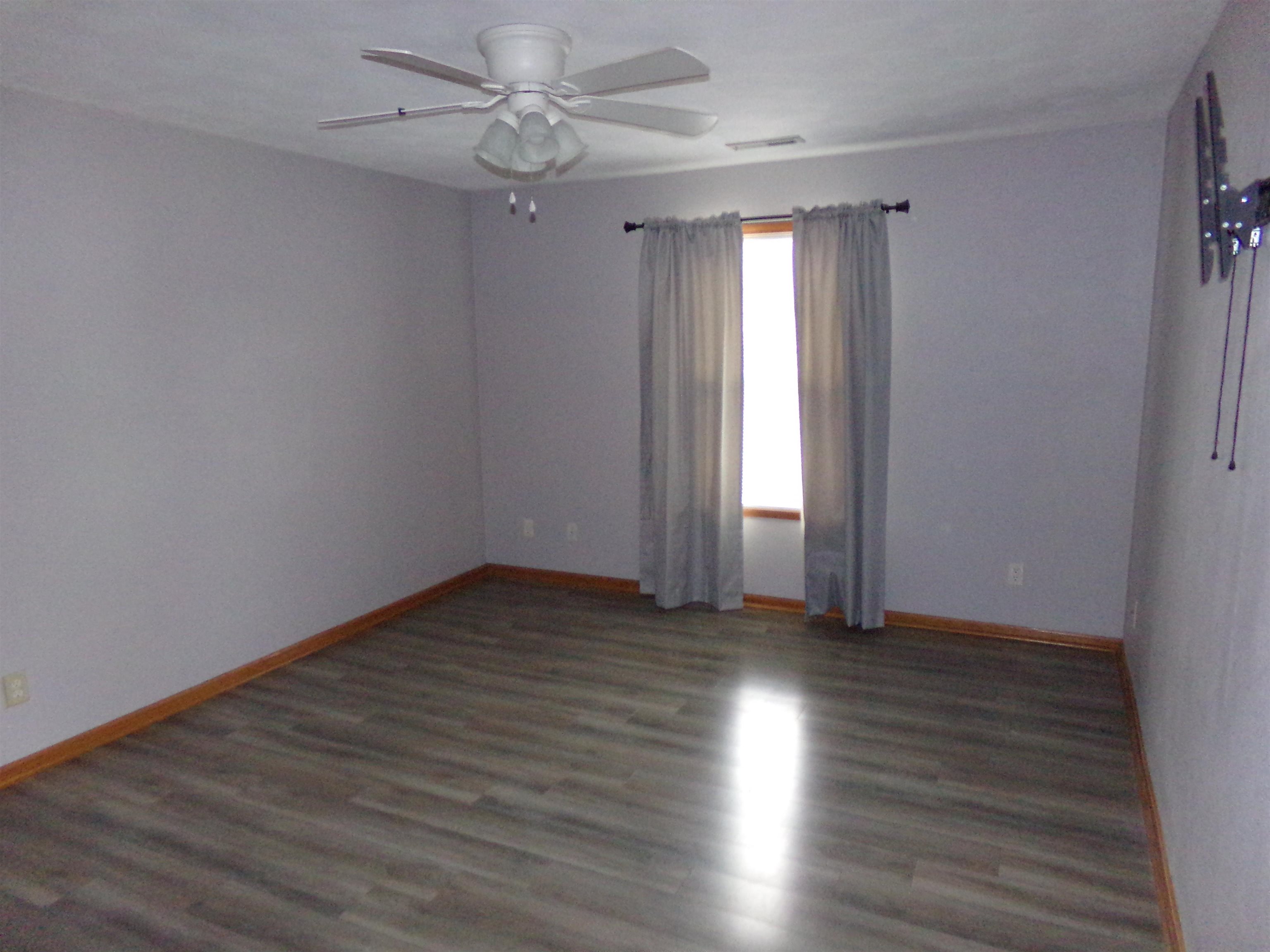 10164 Monarch Road Roscoe, IL 61073 - Photo 8 of 11 an empty room with wooden floor and windows