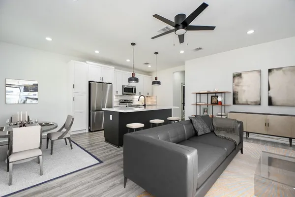 a living room with stainless steel appliances kitchen island granite countertop furniture and a dining table