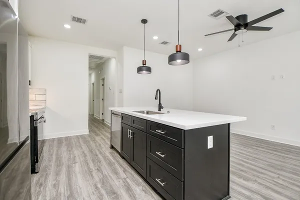 a kitchen with a sink a refrigerator and wooden floor