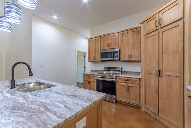 a kitchen with granite countertop cabinets stainless steel appliances and a counter space