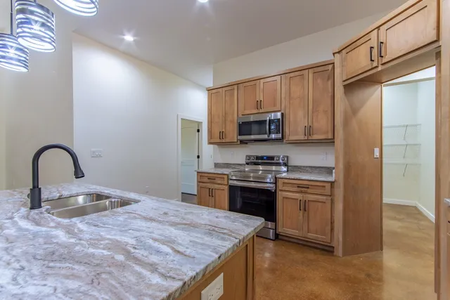 a kitchen with stainless steel appliances granite countertop a stove top oven a sink and dishwasher