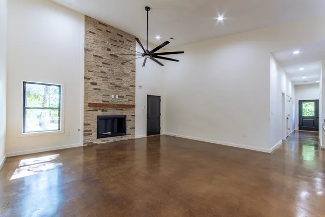 a large kitchen with granite countertop a large counter top a refrigerator and a fireplace