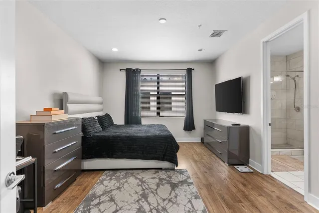 a bedroom with a bed and wooden floor