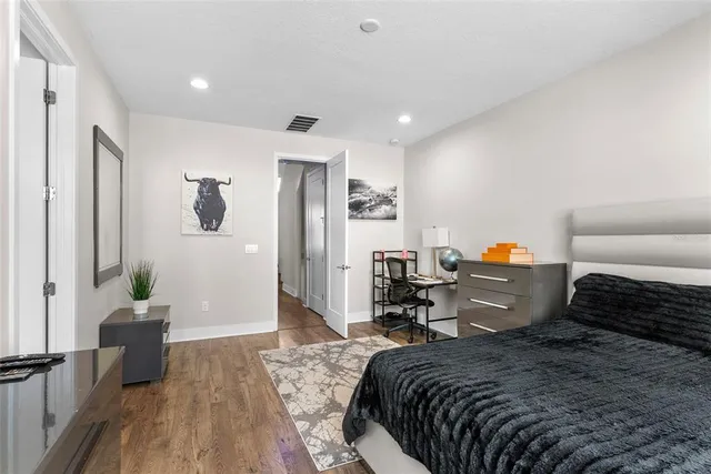 a bedroom with a bed and flat tv screen on the dresser