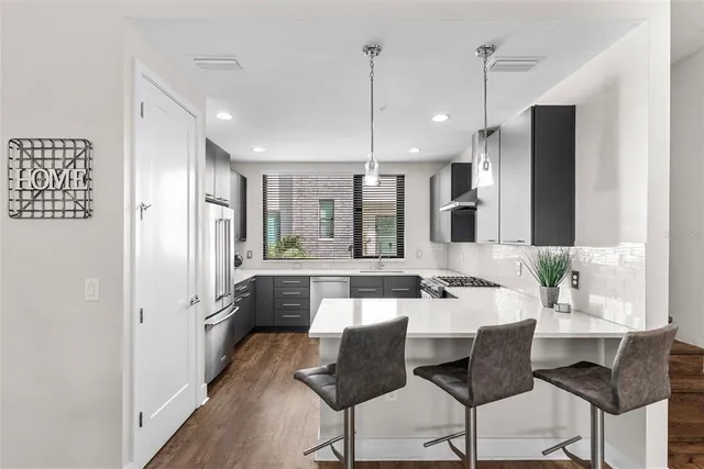 a kitchen with stainless steel appliances granite countertop a sink a stove and a refrigerator