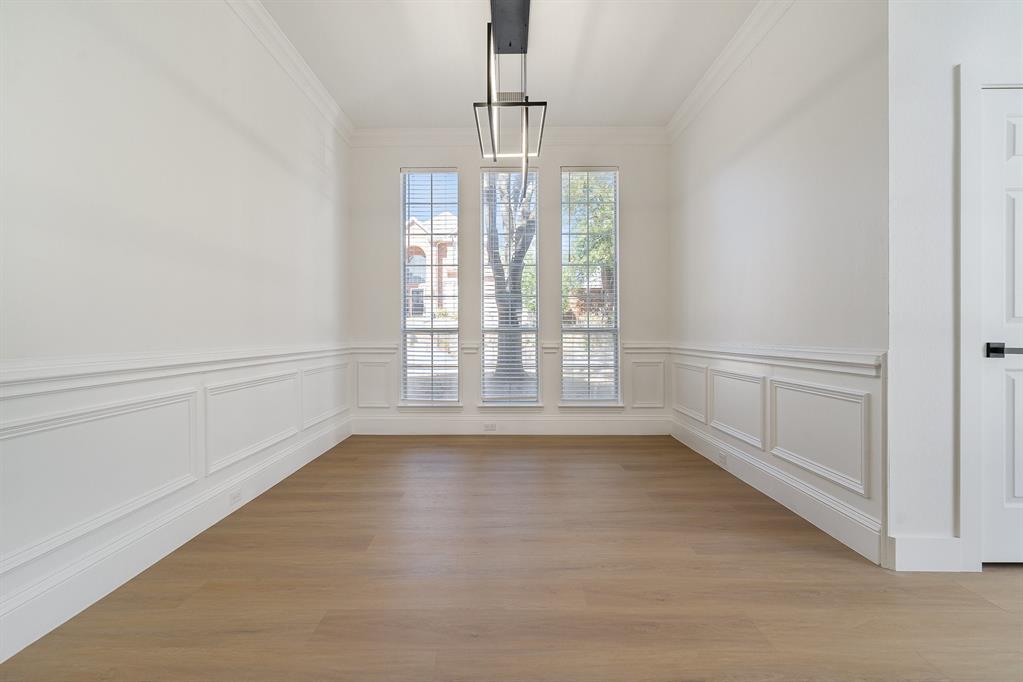 7524 Aberdon Road Dallas, TX 75252 - Photo 15 of 39 Unfurnished dining area with ornamental molding, light wood-type flooring, and a decorative wall