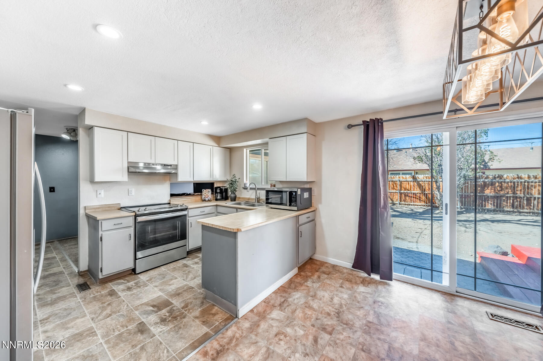 370 Maple Street Fernley, NV 89408 - Photo 13 of 32 a kitchen with stainless steel appliances granite countertop a refrigerator and a stove top oven